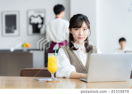 Young woman playing a computer in a cafe 85359879