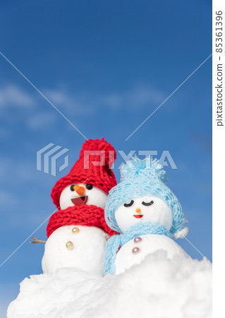 A pair of snowmen with a blue sky A pair of snowmen with a blue sky 85361396