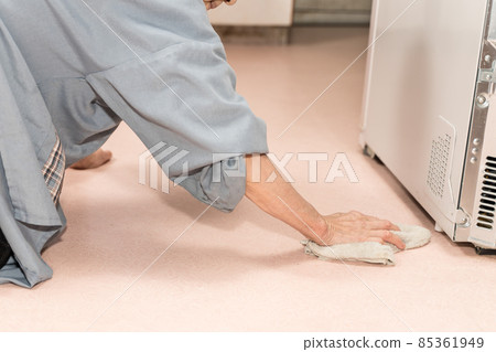 Senior woman polishing the floor with a rag 85361949