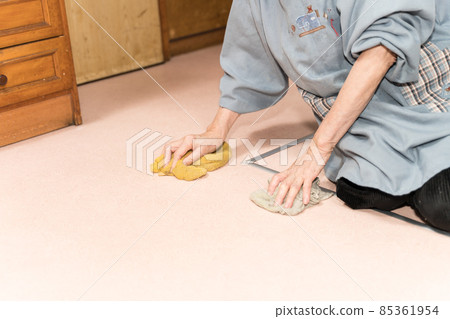 Senior woman polishing the floor with a rag 85361954