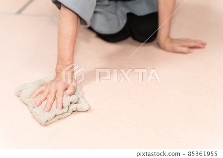 Senior woman polishing the floor with a rag 85361955