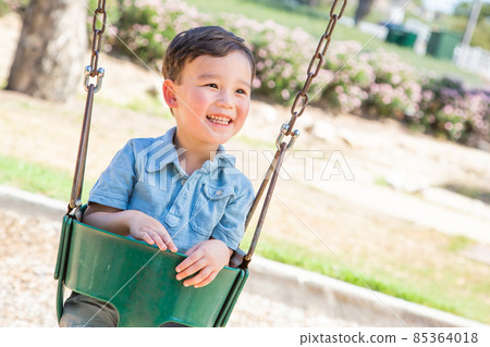 Chinese and Caucasian Boy Having Fun On The Swings At Playground. Chinese and Caucasian Boy Having Fun On The Swings At Playground. 85364018