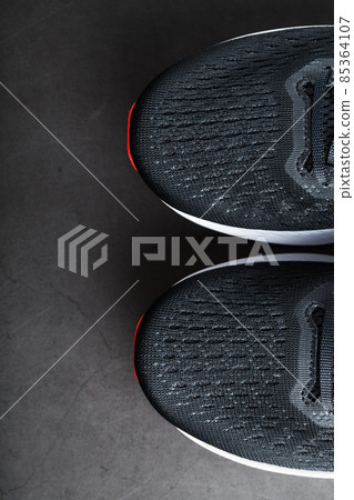 Black sports sneakers with red soles on a black background. Black sports sneakers with red soles on a black background. 85364107