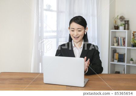 穿著西裝、戴著耳機、打視頻電話的年輕女人 穿著西裝、戴著耳機、打視頻電話的年輕女人 85365654