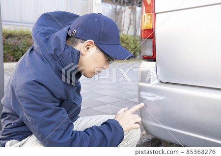 A man who gets depressed by hurting his car at work A man who gets depressed by hurting his car at work 85368276