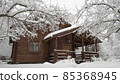 Snow covered country house made of brown logs 85368945
