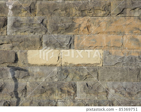 Wall with embossed rectangular stone tiles with a rough texture and spots of paint on it. Texture not seamless Wall with embossed rectangular stone tiles with a rough texture and spots of paint on it. Texture not seamless 85369751