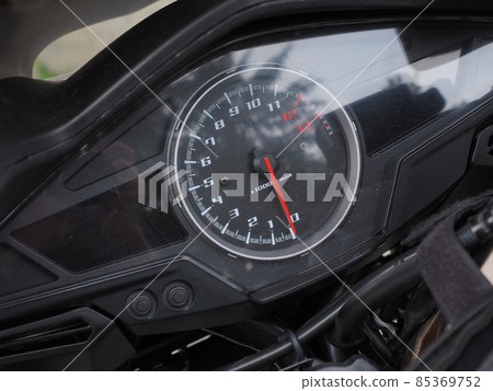 A round speedometer with a red arrow is located on a black motorcycle. Full screen photo A round speedometer with a red arrow is located on a black motorcycle. Full screen photo 85369752
