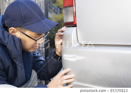 A man who gets depressed by hurting his car at work A man who gets depressed by hurting his car at work 85370822