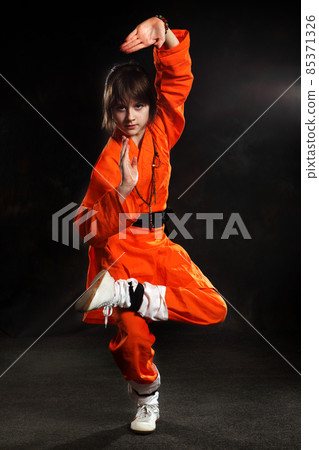Wushu-Girl dressed in orange make exercise of Shaolin taolu 85371326