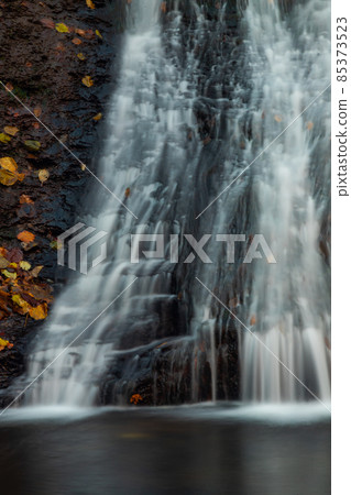 Tranquil waterfall scenery in the middle of autumn forest Tranquil waterfall scenery in the middle of autumn forest 85373523