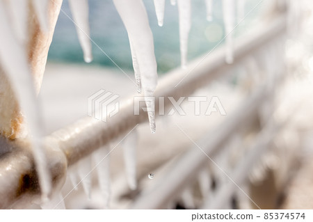 Frozen jetty with icicles on the handrails Frozen jetty with icicles on the handrails 85374574