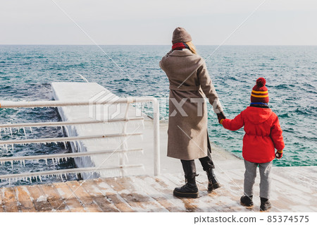 Mother and son on a pier at the sea in winter 85374575