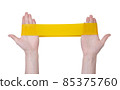 Fitness gums elastic yellow band in hands isolated on white background 85375760