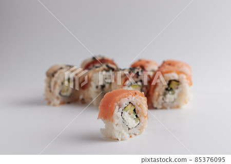 One roll in focus, a portion of rolls out of focus, Asian food, sushi and fish dish One roll in focus, a portion of rolls out of focus, Asian food, sushi and fish dish 85376095