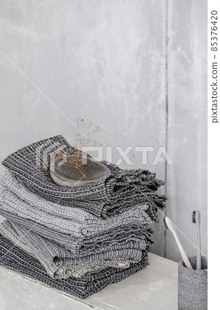 Organic waffle linen towels, bamboo toothbrushes, bathroom zero waste accessories in grey shades in contemporary bathroom interior. Daily body care, spa and wellness zero waste bathroom concept 85376420