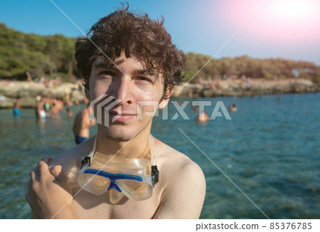 Portrait of a cute Caucasian young man standing at the bay of Porto Selvaggio, Puglia, Italy. Tell us about his experience in this magnificent place. Concept of beach holidays in nature. Portrait of a cute Caucasian young man standing at the bay of Porto Selvaggio, Puglia, Italy. Tell us about his experience in this magnificent place. Concept of beach holidays in nature. 85376785