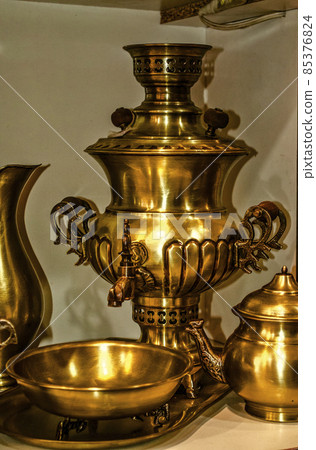 A beautiful brass tea set, a samovar, a kettle, a bowl on legs, a water jug on a wrought-iron tray. A beautiful brass tea set, a samovar, a kettle, a bowl on legs, a water jug on a wrought-iron tray. 85376824