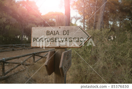 Porto Selvaggio, Puglia, Italy . August 2021. A wooden information sign indicates the direction to the bay along the pine forest. Porto Selvaggio, Puglia, Italy . August 2021. A wooden information sign indicates the direction to the bay along the pine forest. 85376830