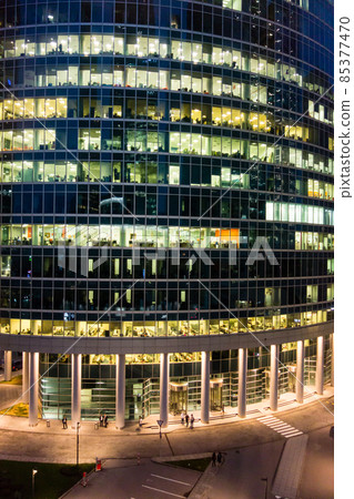 Cylindrical glass-enclosed office building with lights Night view of Moscow cityscape 85377470