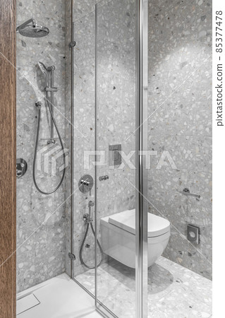 Furnished modern minimalist bathroom interior with bathroom chrome accessories and grey tiles Furnished modern minimalist bathroom interior with bathroom chrome accessories and grey tiles 85377478