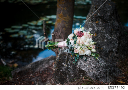 Wedding flower bouquet lies on the rock Wedding flower bouquet lies on the rock 85377492