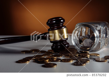 Glass jar with coins and wooden judge gavel. Law concept 85378202