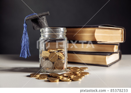 Savings for education concept. Coins in jar with coins and books 85378233