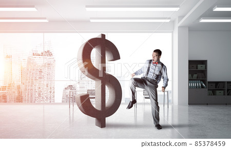 Determined banker man in modern office interior breaking dollar figure Determined banker man in modern office interior breaking dollar figure 85378459