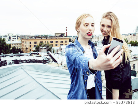 two cool blond real girls friends making selfie on roof top, lifestyle people concept, modern teens two cool blond real girls friends making selfie on roof top, lifestyle people concept, modern teens 85378618