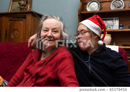 Happy 83 year old senior woman and her 39 year old daughter with the Down Syndrome during Christmas Happy 83 year old senior woman and her 39 year old daughter with the Down Syndrome during Christmas 85379450