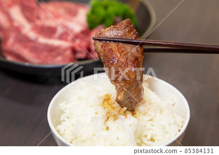 Put grilled meat on rice and eat 85384131