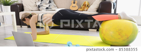 Young athletic woman doing plank on fitball at home 85388355