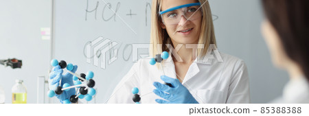 In hands of woman, scientist holds molecular model in laboratory closeup In hands of woman, scientist holds molecular model in laboratory closeup 85388388