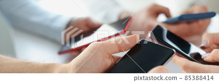 Group of business people holding a smartphone in their hands 85388414