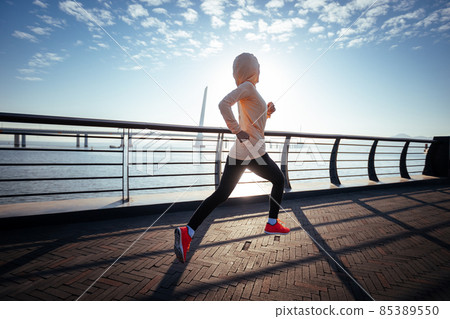 Fitness woman runner running on seaside bridge Fitness woman runner running on seaside bridge 85389550