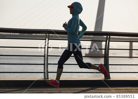Fitness woman runner running on seaside bridge 85389551