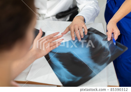 The doctors explain to the patient the reason she is experiencing pain in her lungs. The doctors explain to the patient the reason she is experiencing pain in her lungs. 85390312