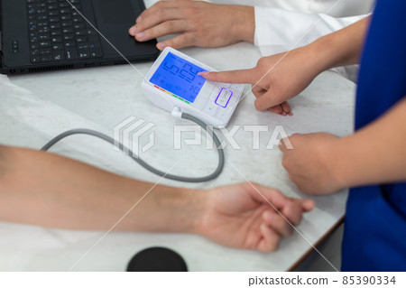 The nurse shows the total blood pressure result. 85390334