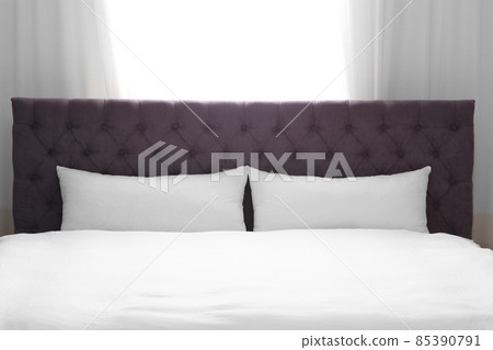 Modern bed with soft pillows near window 85390791