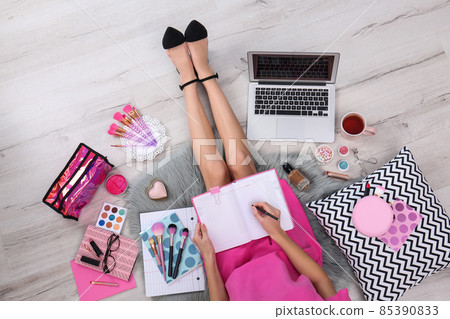 Beauty blogger with laptop and cosmetics sitting on floor, top view 85390833