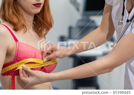 A doctor measures the chest circumference of a young patient. On the second combustible ultrasound machine. A doctor measures the chest circumference of a young patient. On the second combustible ultrasound machine. 85390885