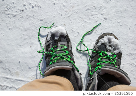 Snow-covered ground and untied shoelaces 85391590
