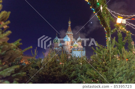 view of St. Basil's Cathedral among green firs, photo was taken on a winter evening. 85395723