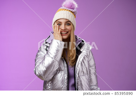 Delighted amused tender blond girlfriend fool around look playful playing snowballs touch cheek astonished feel dream come true enjoying vacation winter holidays boyfriend, standing purple background 85395890