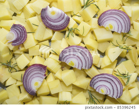 chopped raw potatoes with red onion slices and rosemary leaves chopped raw potatoes with red onion slices and rosemary leaves 85396245