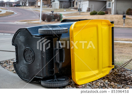 Garbage collection bin blown over by wind in residential area 85396458