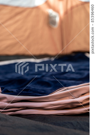 Selective focus of an inflatable air mattress on the floor of a tent being filled up.  85396460