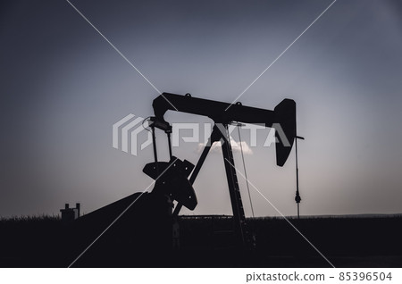 Oil pump jack against an open sky in a rural midwest corn field Oil pump jack against an open sky in a rural midwest corn field 85396504
