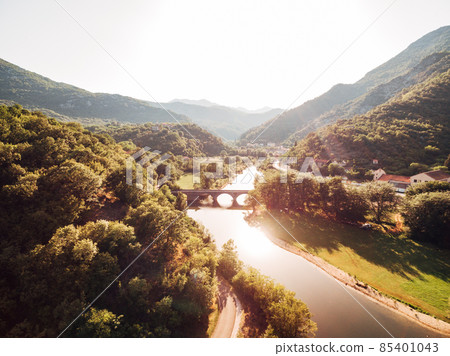 Bridge over the Crnojevica river among green mountains. Montenegro Bridge over the Crnojevica river among green mountains. Montenegro 85401043
